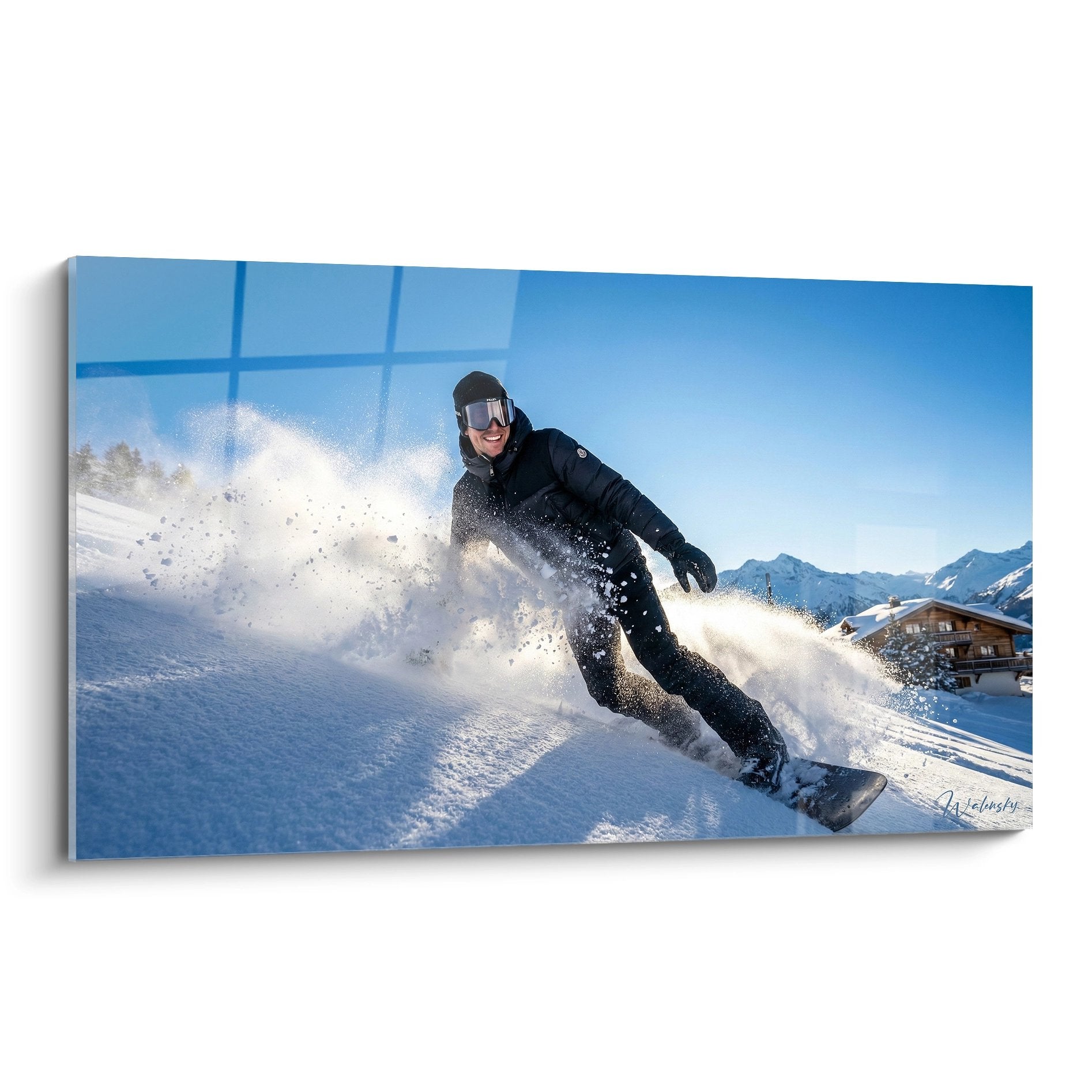 Snowboarder im schwarzen Outfit fährt durch Pulverschnee mit Schneewolke vor Alpenkulisse