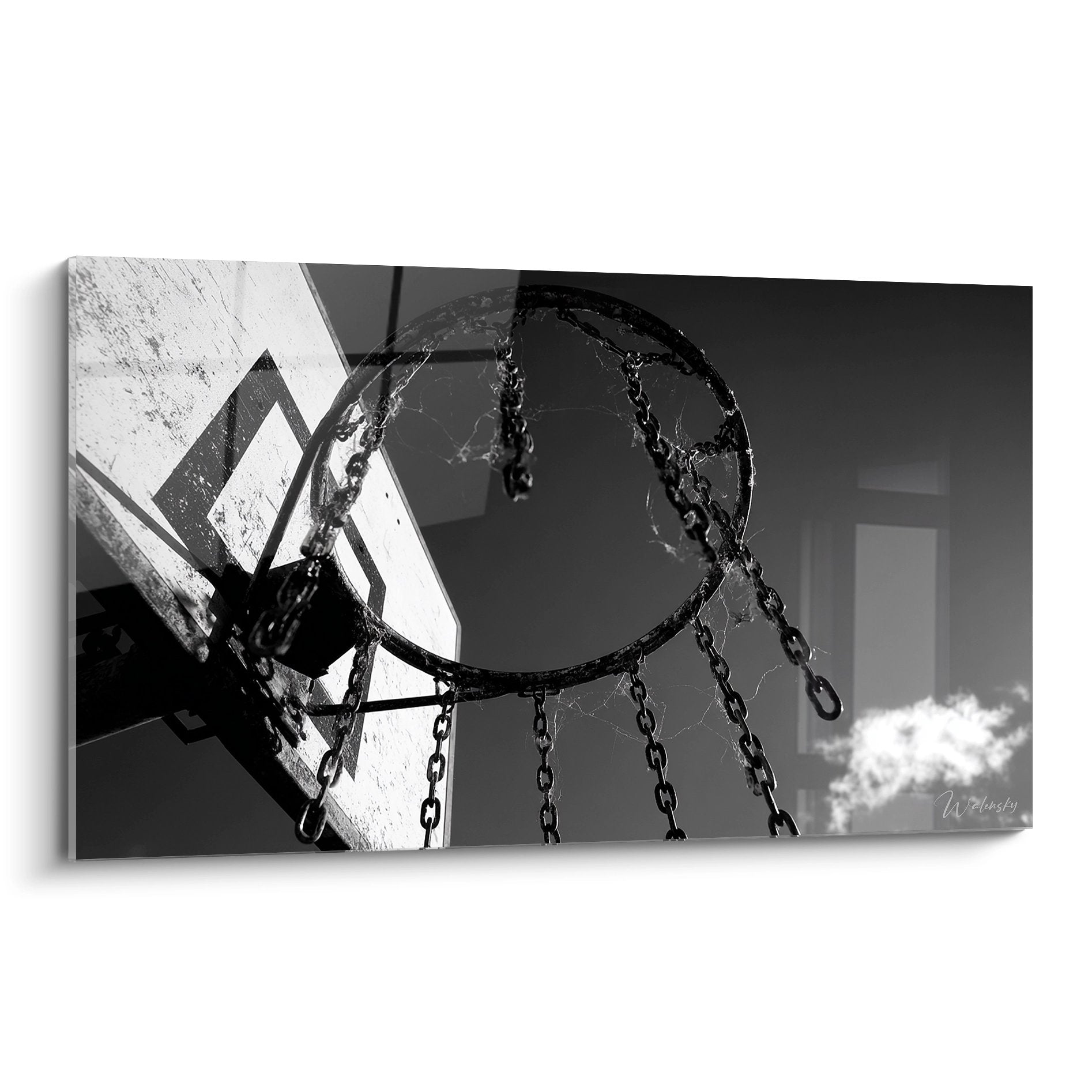 Schwarz-weiß Basketball-Korb von unten fotografiert mit hängenden Ketten und urbanem Hintergrund