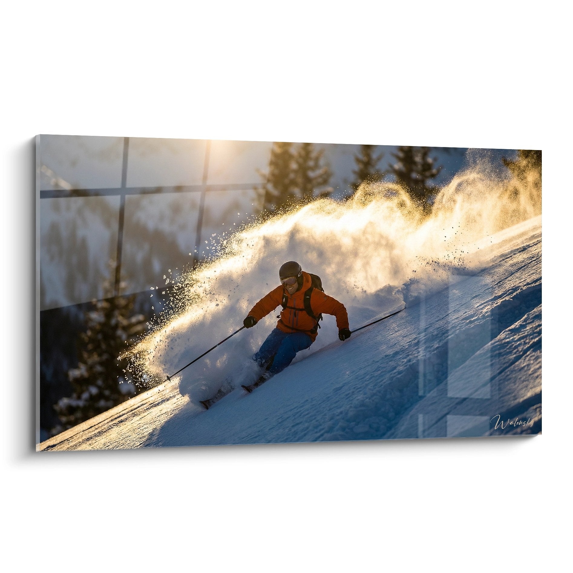 Skifahrer in orangener Jacke gleitet durch Pulverschnee bei goldenem Sonnenlicht mit spektakulärer Schneefontäne