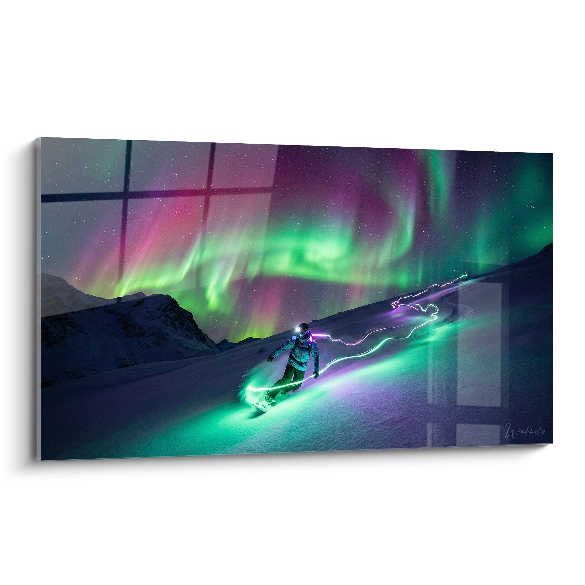 Snowboarder unter grün-violettem Nordlicht in verschneiter Berglandschaft mit Aurora Borealis