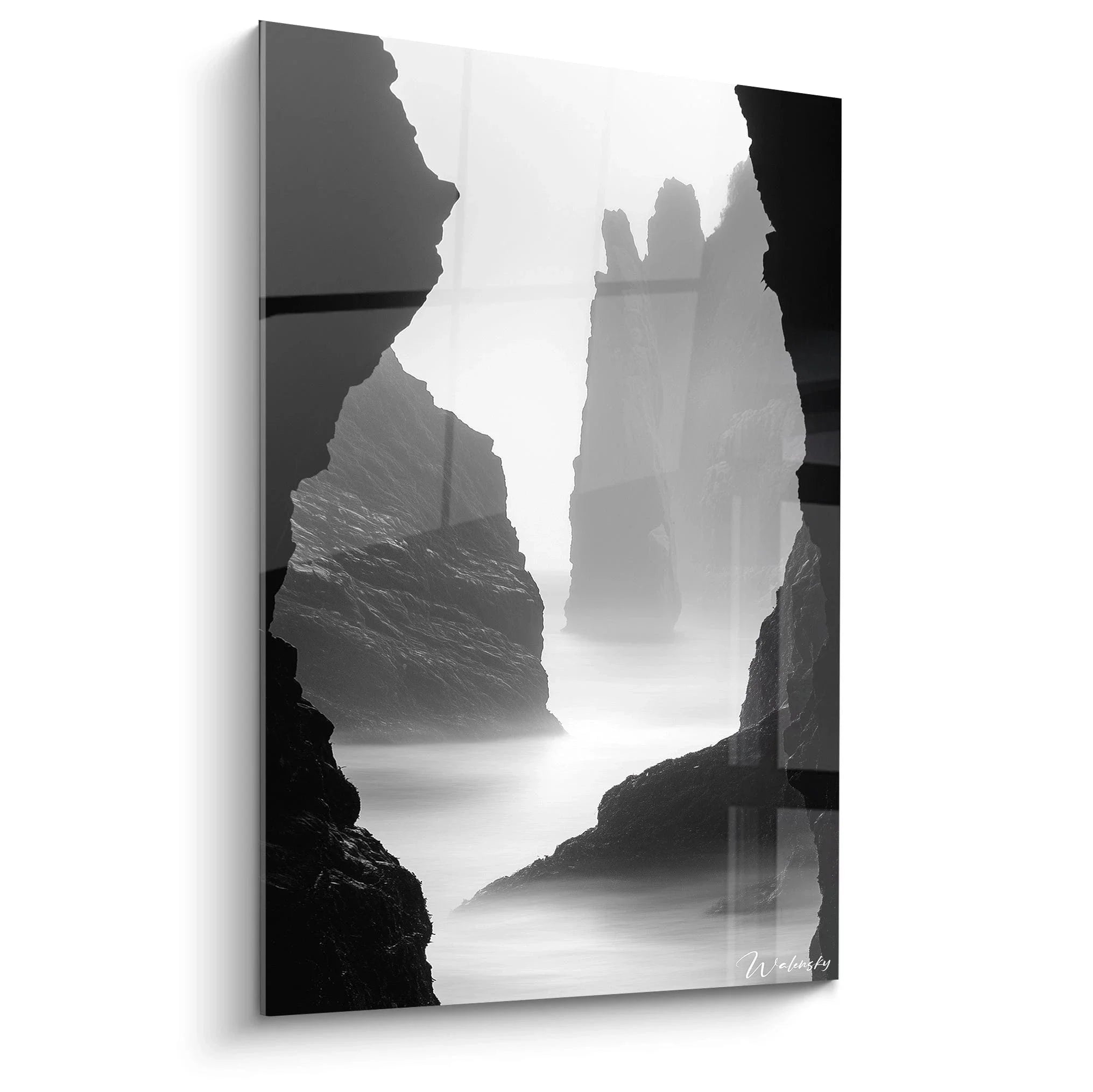 Wandbild Küstenfelsen in schwarz-weiß mit mystischem Nebel und dramatischen Felsformationen