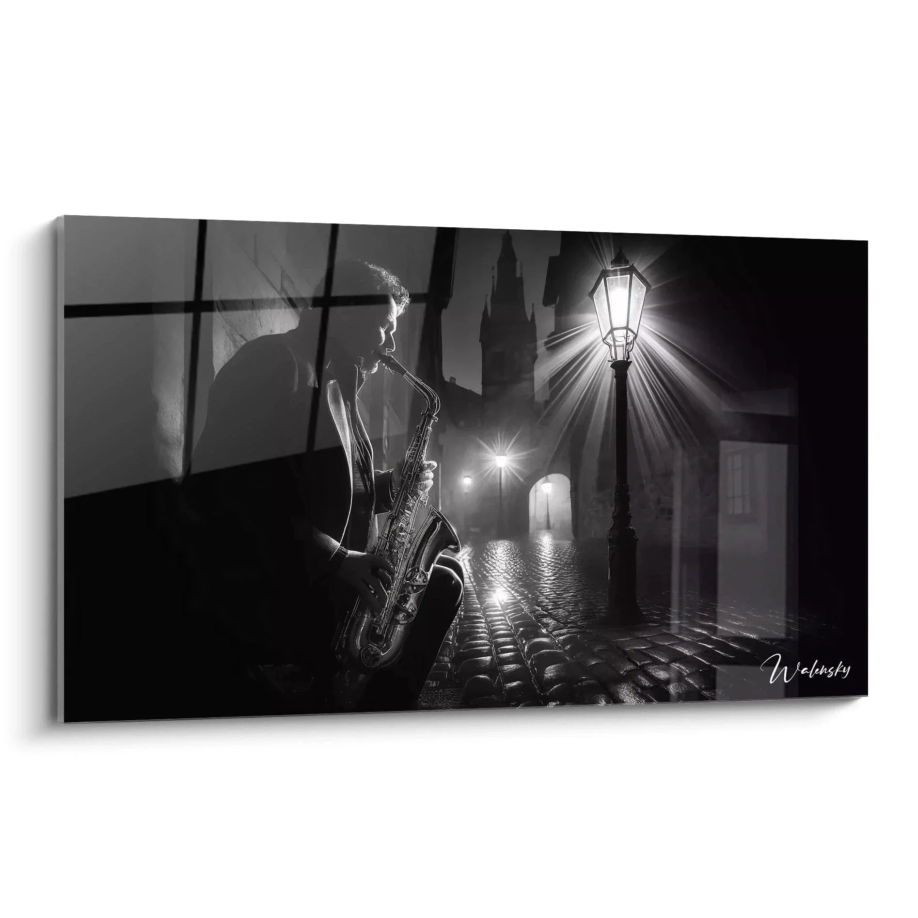 Wandbild Saxophonist spielt nachts unter Straßenlaterne auf Kopfsteinpflaster schwarz-weiß