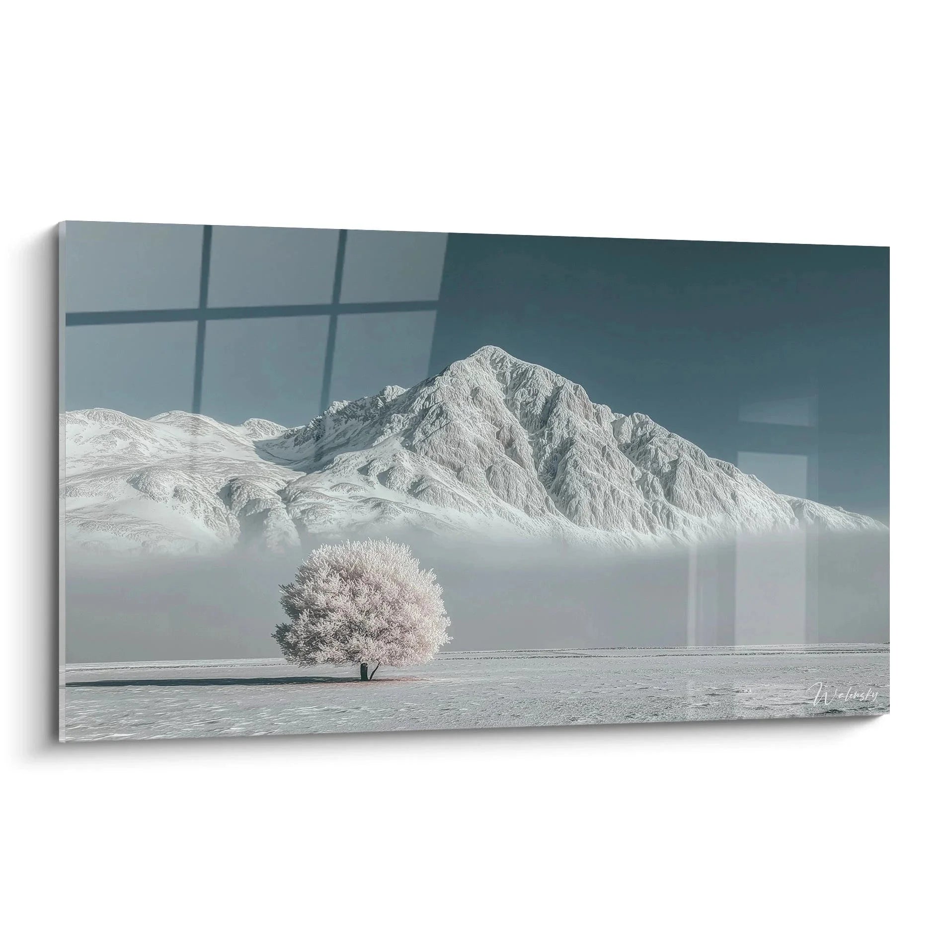 Wandbild Winterlandschaft mit einsamem blühendem Baum vor nebelverhangenen Bergen